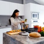 woman smiling while cooking