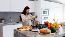 woman smiling while cooking